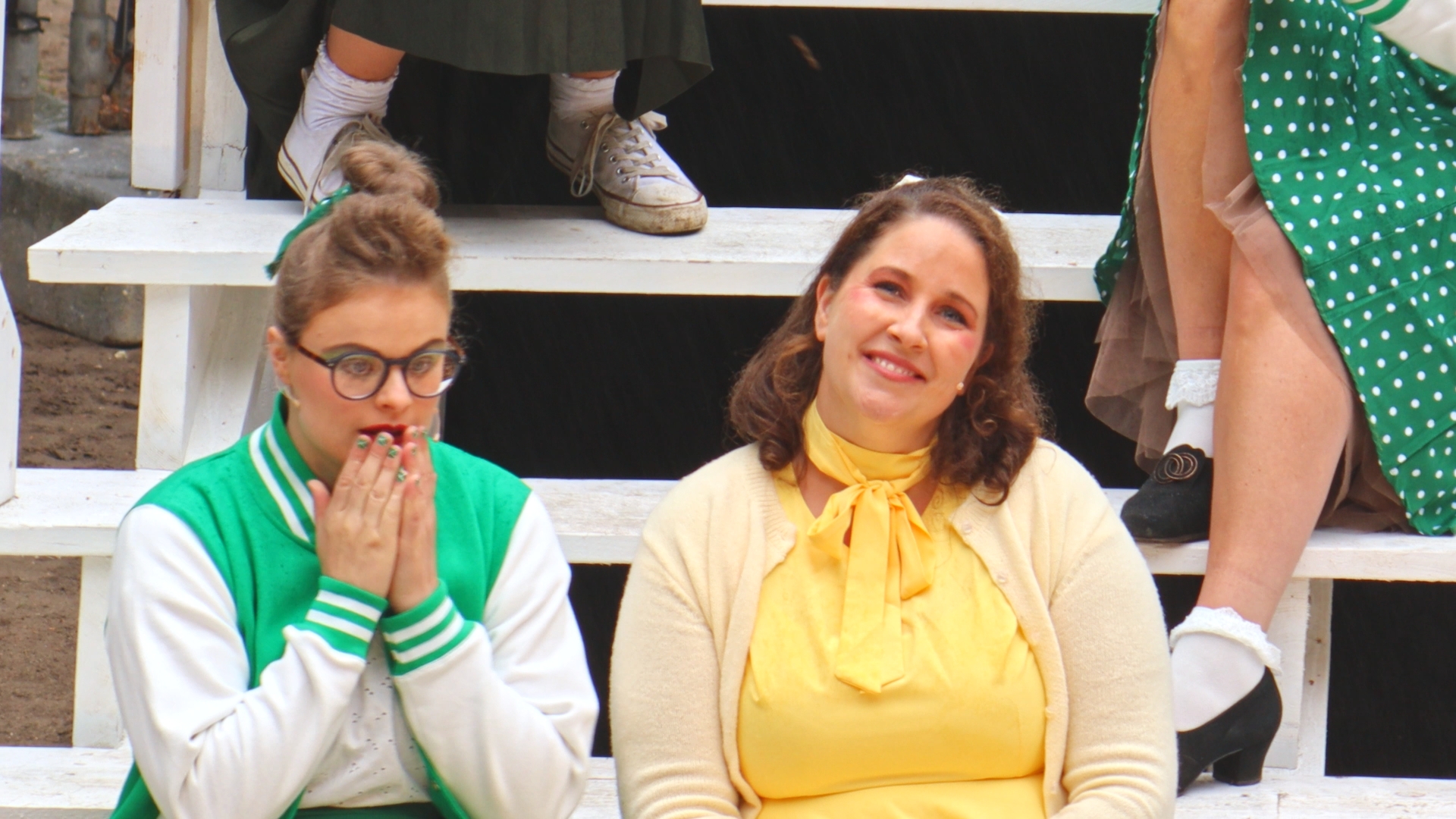 vrouw in jaren 50 outfit zittend naast vriendinnen