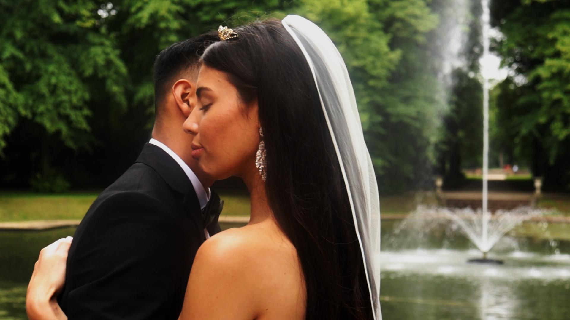 Bruidspaar in een omhelsing voor een fontein